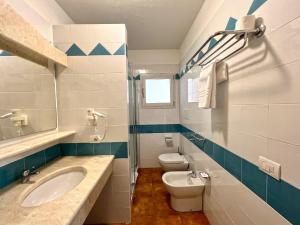 a bathroom with a sink and a toilet at Le Residenze del Maria Rosaria - Via Trentino 62 in Orosei +13 photos