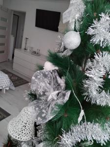 Un árbol de Navidad con adornos de plata y blanco. en La Monica 2 - Cazare Straja - Lupeni - Retezat - Parang, en Lupeni