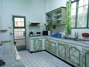 une cuisine avec des placards en acier inoxydable et un évier dans l'établissement Orient Guesthouse Auberge, à Mahébourg