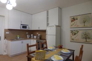 a kitchen with white cabinets and a table with chairs at Apartmán v Bételu in Chrastava