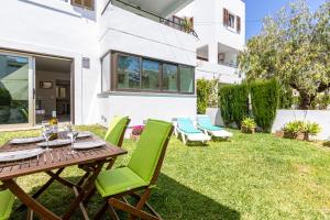 a patio with a table and chairs on the grass at VISTA MONTE II - Francisca in El Port
