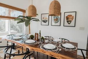 a dining room with a table with plates and chairs at Glamour Mountain Getaway by Casa Oso with views and spa in Oakhurst