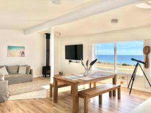 uma sala de estar com uma mesa e um sofá em The Landing Aldinga Beach Front Private Pool em Aldinga Beach