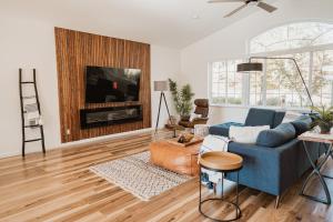 a living room with a blue couch and a tv at Glamour Mountain Getaway by Casa Oso with views and spa in Oakhurst