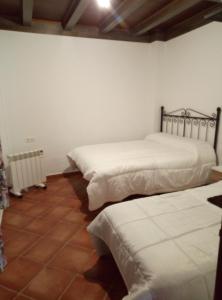 a bedroom with two beds and a tiled floor at CASA RURAL El Paso in Prado del Rey