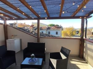a patio with chairs and a table on a balcony at Charlie's Home Arezzo-Appartamento-B&B Arezzo con Parcheggio privato- Arezzo Città del Natale 2023 - Centro Arezzo Fiere e Congressi- Mercatini Natale Arezzo Casa di Babbo Natale e Villaggio Tirolese 2023 in Arezzo