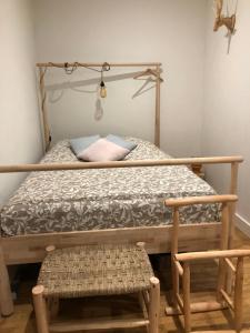 a bedroom with a bed with a wooden frame and a bench at Juste au dessus de la Veules in Veules-les-Roses