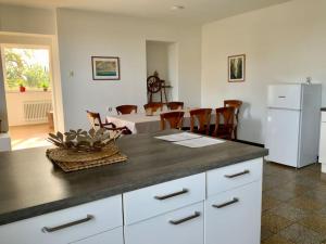 a kitchen with a counter and a dining room with a white refrigerator at Pension Altes Rathaus in Aachen