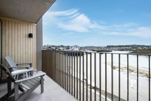 a balcony with a chair and a view of the ocean at Primero Apartments - Hayle Villas in Hayle