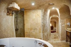 y baño con bañera y ducha a ras de suelo. en Karma Suites Cappadocia en Uchisar