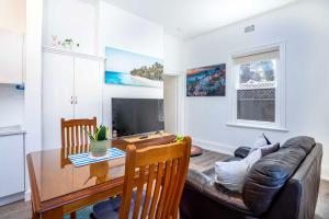 uma sala de estar com um sofá e uma mesa em One Bedroom Apartment on Summer/ No.2 near CBD em Orange