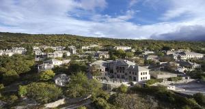 une vue aérienne sur une ville avec des maisons et des arbres dans l'établissement MounTrace Suites & SPA, à Monodendri