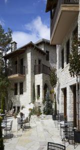 a building with tables and chairs in front of it at MounTrace Suites & SPA in Monodendri