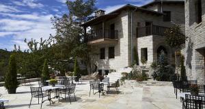a patio with tables and chairs in front of a building at MounTrace Suites & SPA in Monodendri