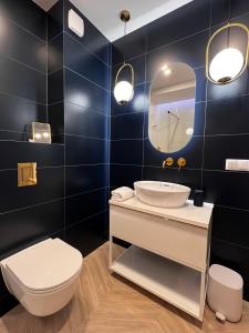 a bathroom with a sink and a toilet and a mirror at Grand Apartament in Złotów