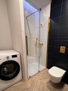 a bathroom with a washing machine and a washer at Grand Apartament in Złotów
