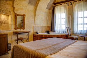 烏奇薩爾的住宿－Karma Suites Cappadocia，一间卧室配有一张床和浴缸