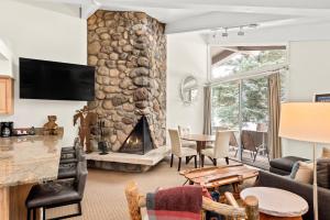 a living room with a stone fireplace at Standard 2 Bedroom - Aspen Alps #115 in Aspen