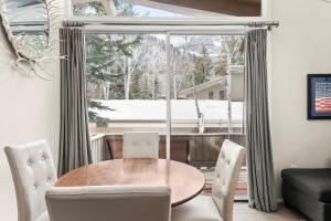 ein Esszimmer mit einem Tisch und Stühlen vor einem Fenster in der Unterkunft Standard 2 Bedroom - Aspen Alps #115 in Aspen