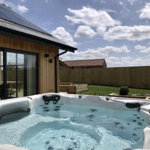 a hot tub in the backyard of a house at Mallard Cottage, Ashlin Farm Barns in Lincoln