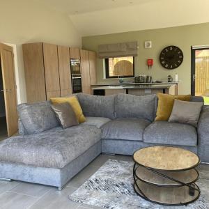 a living room with a couch and a table at Water Lily Cottage, Ashlin Farm Barns in Lincoln