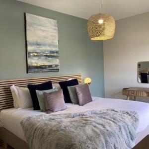 sypialnia z dużym białym łóżkiem z fioletowymi poduszkami w obiekcie Water Lily Cottage, Ashlin Farm Barns w mieście Lincoln