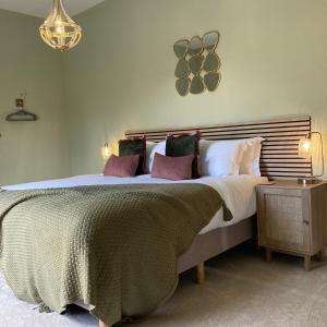 - une chambre avec un grand lit et des oreillers dans l'établissement Castle Hill Barn, Ashlin Farm Barns, à Lincoln