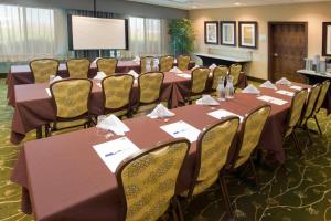 a conference room with tables and chairs and a projection screen at Holiday Inn Express & Suites Logan, an IHG Hotel in Logan