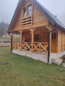 een grote houten hut met een poort in een veld bij Vikendica Jankovic in Pale