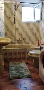 uma casa de banho com uma banheira, um WC e um lavatório. em Ομορφο διαμερισμα με μεγαλες βεραντες em Atenas
