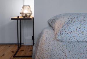 a lamp on a side table next to a bed at Résidence Celestins - Appartements centre avec parking in Vichy