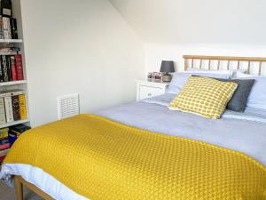 a bedroom with a bed with a yellow blanket at Cosy Apartment in Winchester