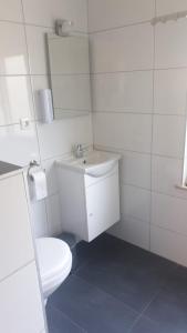 a white bathroom with a toilet and a sink at Hotel B&B Sint-Maria NEXT DOOR in Valkenburg