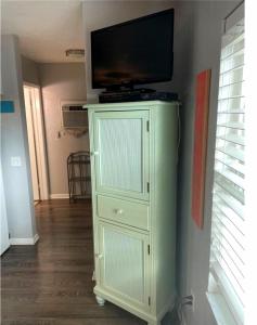 a green cabinet with a television on top of it at Searenity, Waterside studio in the heart of Treasure Island, walk to beach in St. Pete Beach