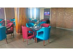 een restaurant met blauwe en rode stoelen en een tafel bij Hotel JB Skyhilton Inn, Alambagh in Charbagh