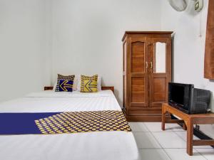 1 dormitorio con 1 cama y TV en una mesa en SPOT ON 91935 Hellena Guesthouse, en Demak
