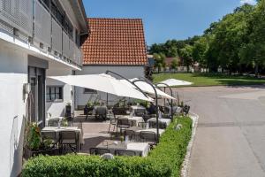 eine Außenterrasse mit Tischen, Stühlen und Sonnenschirmen in der Unterkunft Gasthaus Hotel Zum Mohren in Niederstotzingen