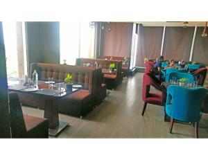 ein Restaurant mit Tischen, Stühlen und Tischen in der Unterkunft Hotel JB Skyhilton Inn, Alambagh in Charbagh