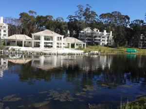 a house on the water with buildings in the background at Green Park in Punta del Este