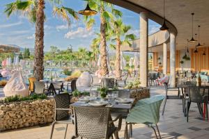 an outdoor patio with tables and chairs and palm trees at Terme di Hissar Camping in Hisarya