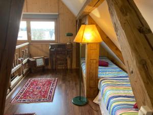 a room with a bed and a lamp and a table at Le Grenier in Marlenheim