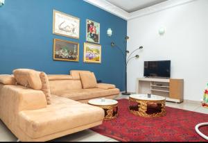 a living room with a couch and a tv at DUPLEXE HAUT STANDING centre ville Quartier Fouda in Yaoundé