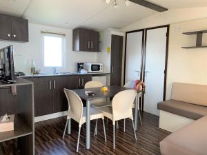 a kitchen and dining room with a table and chairs at Camping Duguesclin in Saint-Coulomb