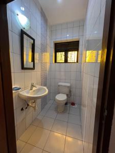 La salle de bains est pourvue de toilettes et d'un lavabo. dans l'établissement Farm Cottage, à Mukono