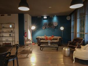 ein Wohnzimmer mit einem Sofa und einer blauen Wand in der Unterkunft Hotel La Meridiana in Perugia