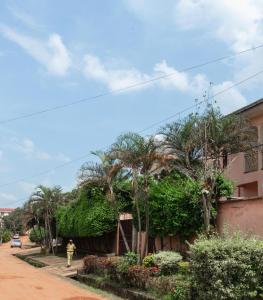 a man walking down a street next to a house at DUPLEXE HAUT STANDING centre ville Quartier Fouda in Yaoundé