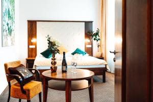 a hotel room with a bed and a table and a room at Hotel Baltaci Atrium in Zlín