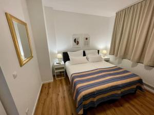 ein Schlafzimmer mit einem Bett mit zwei Lampen und einem Fenster in der Unterkunft Ferienwohnung Freude am Kurpark in Bad Neuenahr-Ahrweiler