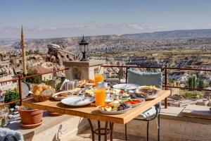 a table with food and drinks on a balcony with a view at Karma Cappadocia in Uçhisar