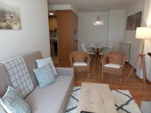 Una sala de estar con un sofá y sillas y una mesa. en BPIRINEOS-Parque Los Tilos 3, en Benasque